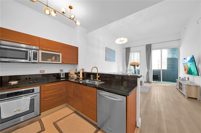 244 Biscayne Blvd Unit 206, Miami, FL 33132 - kitchen featuring stainless steel appliances, a sink, a peninsula, open floor plan, and brown cabinets