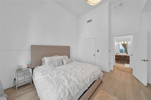 244 Biscayne Blvd Unit 206, Miami, FL 33132 - bedroom featuring high vaulted ceiling, light wood-style flooring, baseboards, and connected bathroom