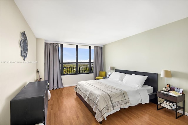 bedroom featuring baseboards and wood finished floors