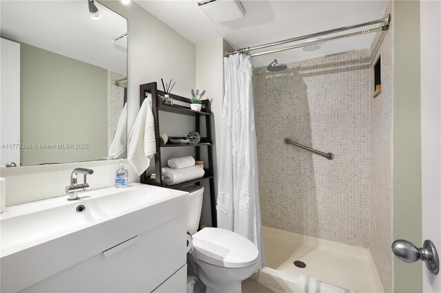 bathroom with toilet, a shower stall, and vanity