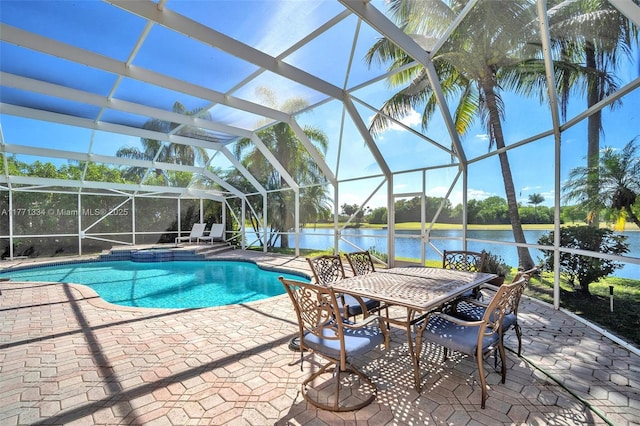 view of swimming pool featuring a pool with connected hot tub, a lanai, a water view, and a patio