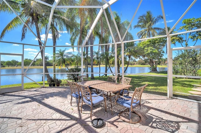 view of patio / terrace with glass enclosure, outdoor dining space, and a water view
