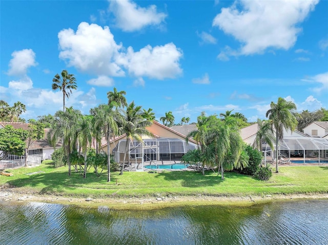 back of house with an outdoor pool, a water view, glass enclosure, and a lawn