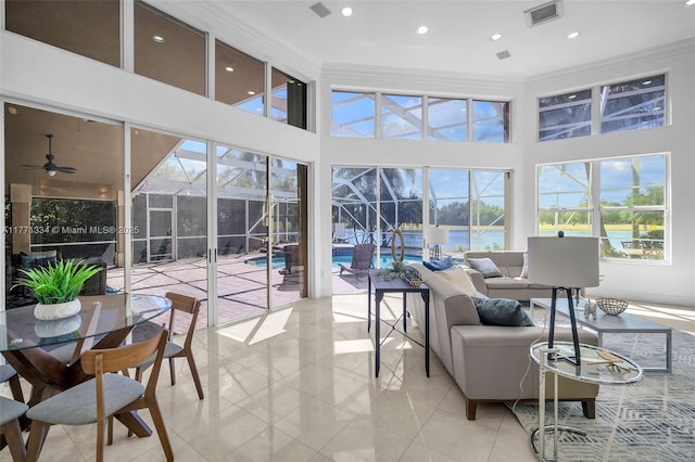 sunroom featuring outdoor lounge area, a water view, visible vents, and a ceiling fan
