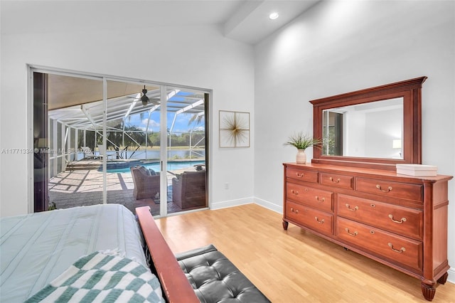 bedroom featuring a sunroom, baseboards, access to outside, light wood-style floors, and vaulted ceiling