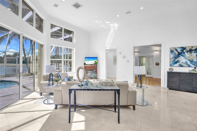 living area with tile patterned floors, a towering ceiling, recessed lighting, and visible vents