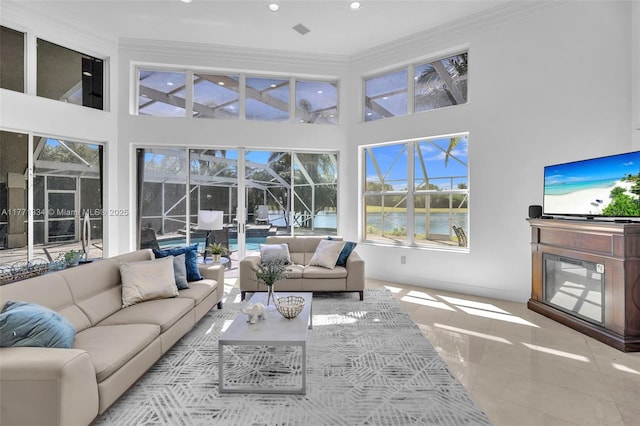 tiled living area featuring ornamental molding, recessed lighting, and a towering ceiling