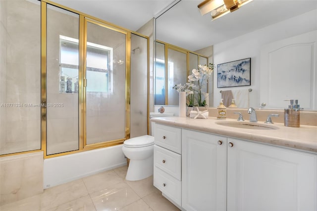 bathroom featuring toilet, vanity, combined bath / shower with glass door, and tile patterned flooring