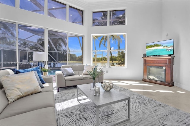 tiled living area featuring baseboards and a towering ceiling