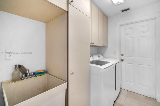 laundry room featuring light tile patterned floors, separate washer and dryer, a sink, visible vents, and cabinet space