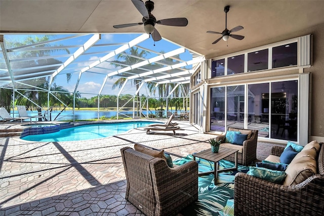 view of pool featuring a patio, glass enclosure, a ceiling fan, a pool with connected hot tub, and outdoor lounge area