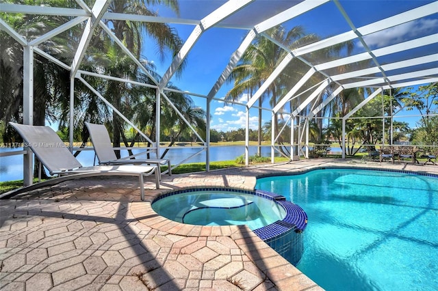 view of swimming pool featuring glass enclosure, a pool with connected hot tub, a water view, and a patio