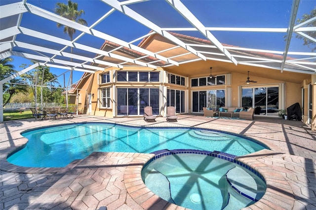 view of swimming pool with a pool with connected hot tub, glass enclosure, and a patio