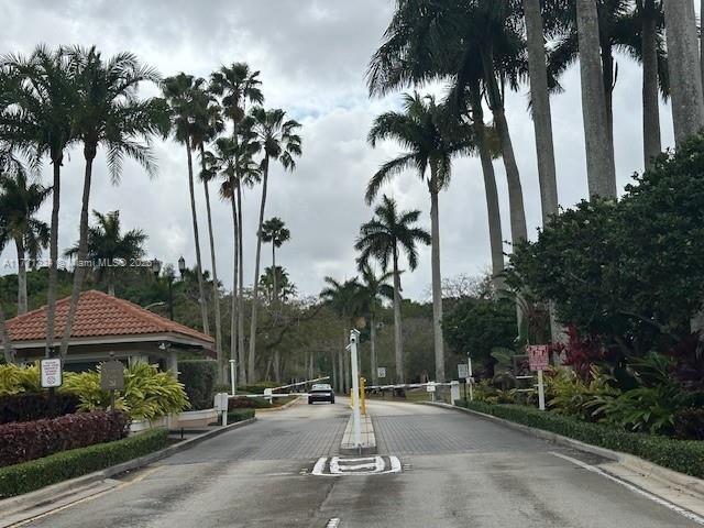 view of street featuring a gated entry and curbs