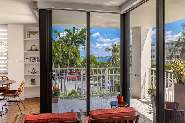 entryway with a wealth of natural light, expansive windows, and wood finished floors
