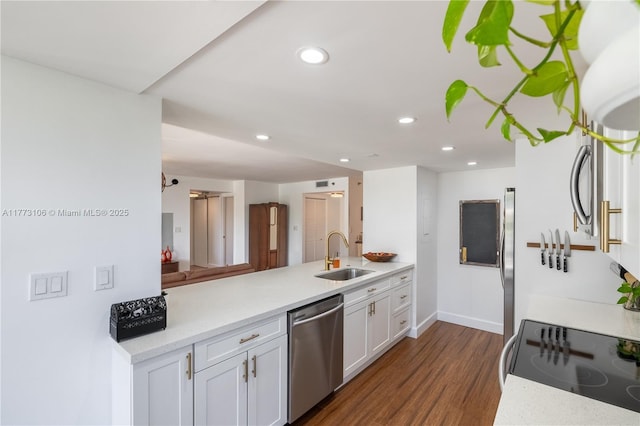 kitchen with light countertops, white cabinets, stainless steel appliances, recessed lighting, and a sink