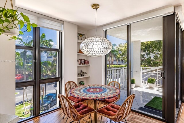 dining space featuring expansive windows and wood finished floors