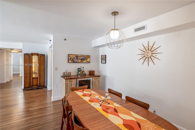 dining space featuring baseboards, visible vents, and dark wood-type flooring