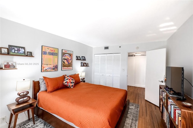 bedroom with visible vents, a closet, and wood finished floors