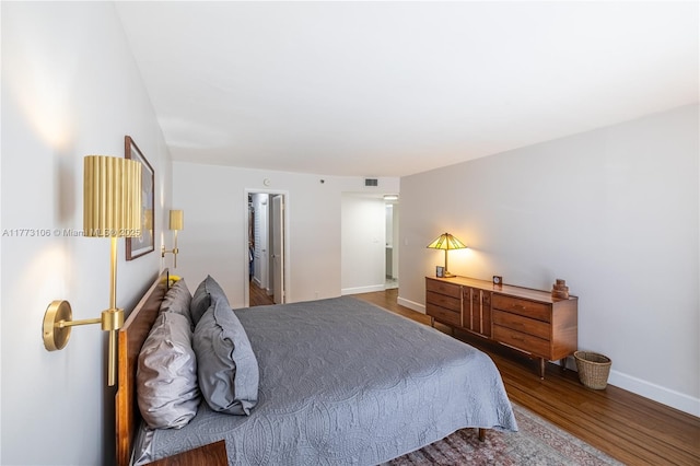 bedroom featuring visible vents, baseboards, and wood finished floors