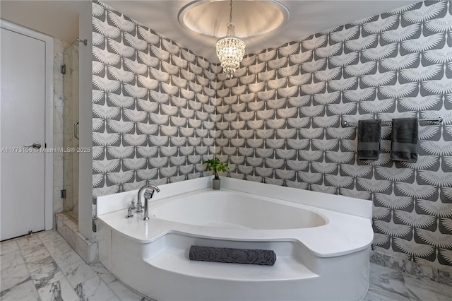 bathroom featuring a bath, marble finish floor, a stall shower, and a notable chandelier