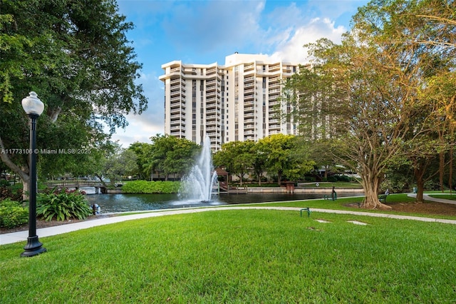 view of home's community featuring a lawn and a water view