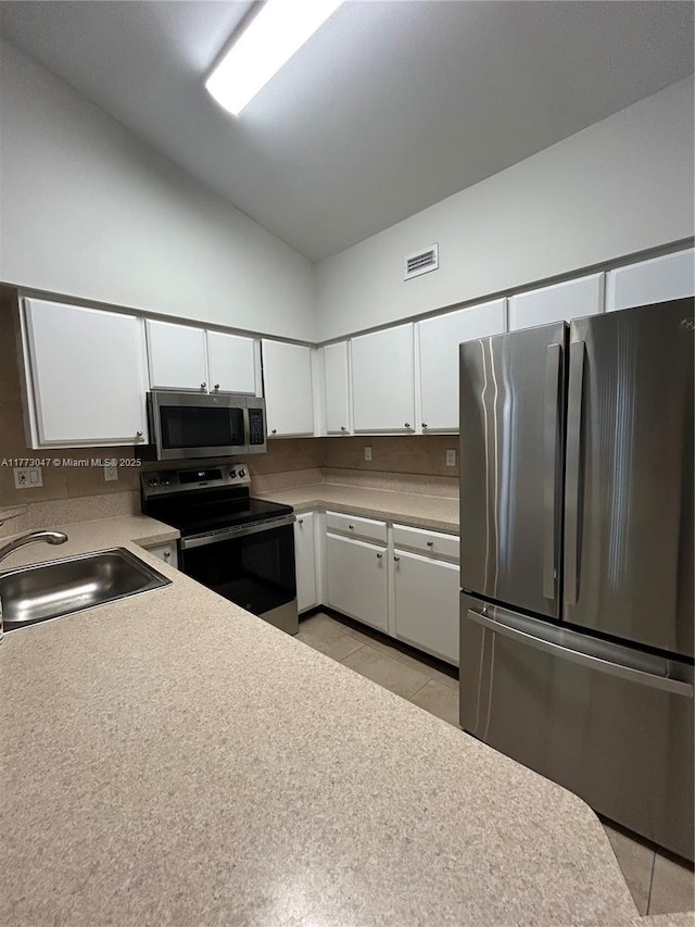 2445 SW 18th Ter Unit 1119, Fort Lauderdale, FL 33315 - kitchen with white cabinets, visible vents, appliances with stainless steel finishes, high vaulted ceiling, and a sink