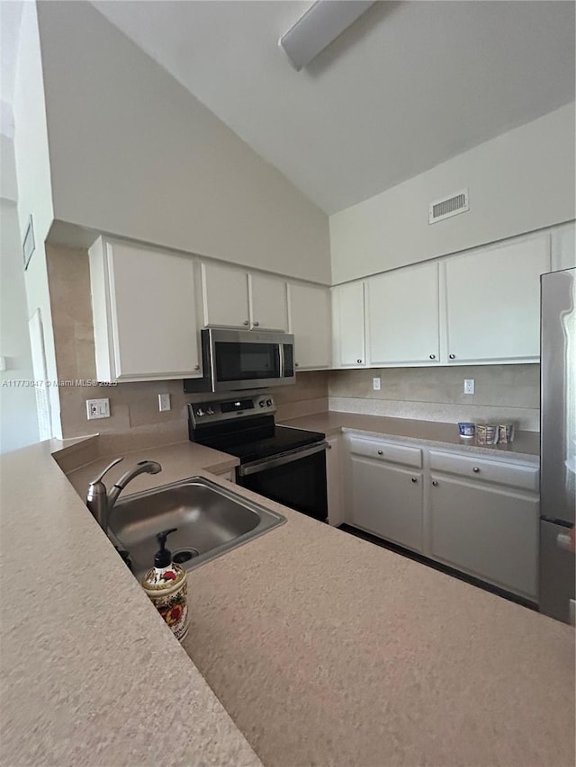 2445 SW 18th Ter Unit 1119, Fort Lauderdale, FL 33315 - kitchen with high vaulted ceiling, white cabinetry, visible vents, a sink, and stainless steel appliances