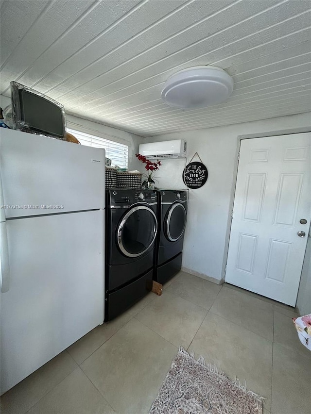 clothes washing area with an AC wall unit, independent washer and dryer, laundry area, and light tile patterned floors