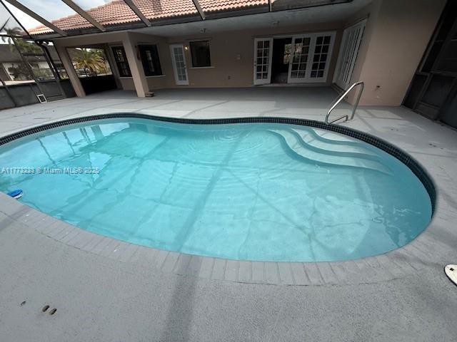 outdoor pool with a lanai and a patio