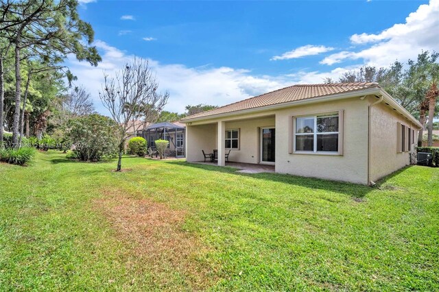 6843 Montrose Way, Boynton Beach, FL 33437 - back of house featuring stucco siding, a patio, and a lawn