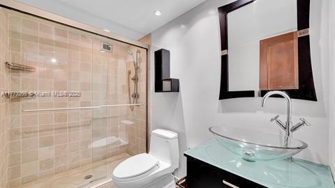 full bath featuring vanity, toilet, and a stall shower
