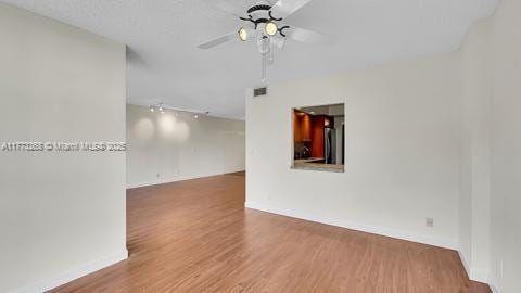 unfurnished room featuring visible vents, a ceiling fan, and wood finished floors