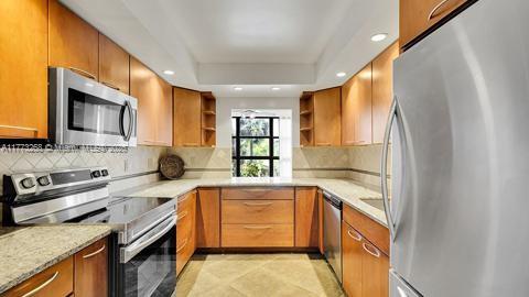 kitchen featuring open shelves, recessed lighting, a raised ceiling, tasteful backsplash, and appliances with stainless steel finishes