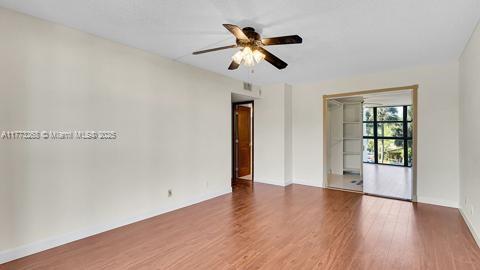 unfurnished room with a ceiling fan, baseboards, and wood finished floors