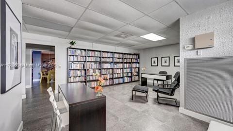 home office with baseboards and a drop ceiling