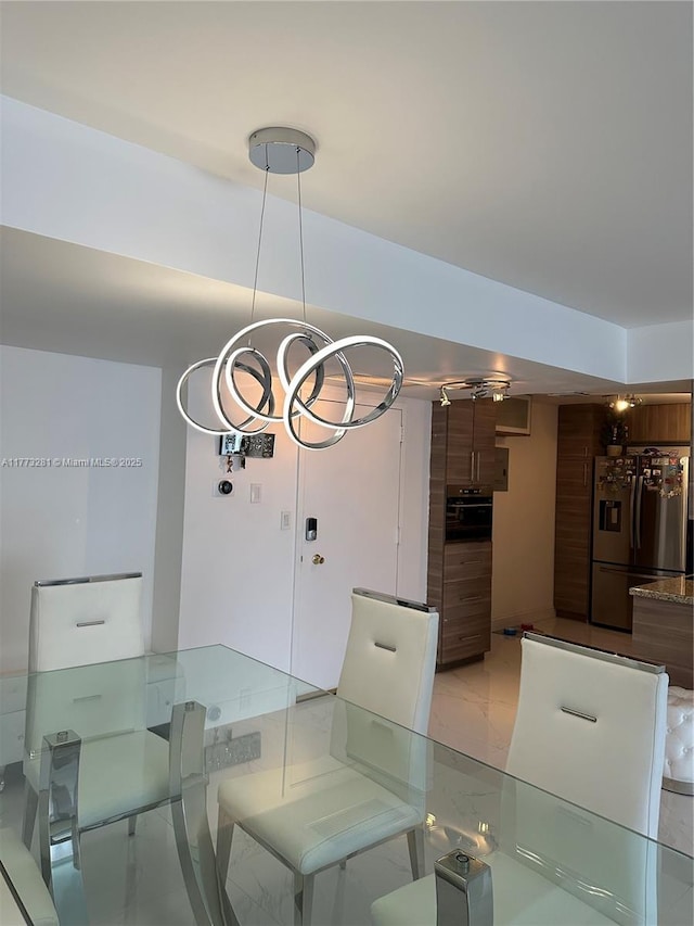 427 Golden Isles Dr Unit 5G, Hallandale Beach, FL 33009 - dining room with marble finish floor and an inviting chandelier