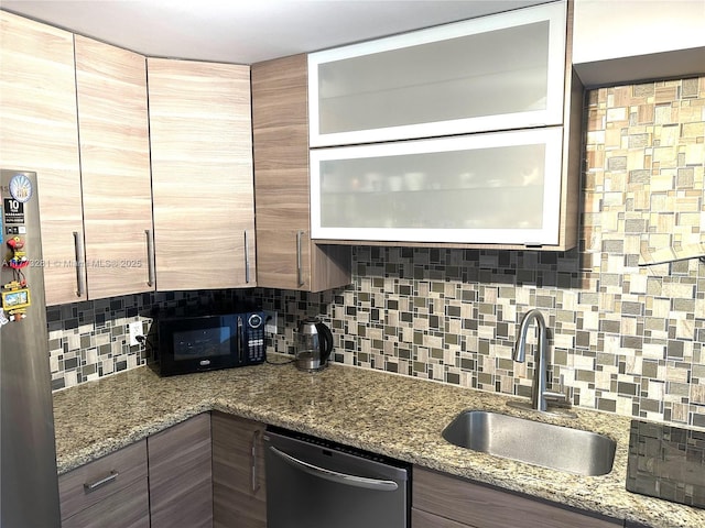 427 Golden Isles Dr Unit 5G, Hallandale Beach, FL 33009 - kitchen with glass insert cabinets, black microwave, dishwasher, a sink, and backsplash