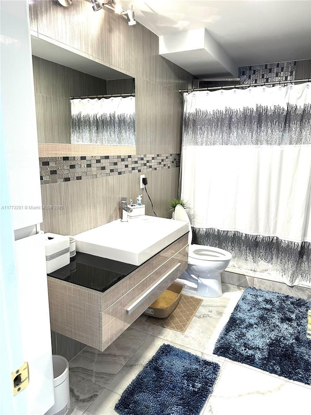 427 Golden Isles Dr Unit 5G, Hallandale Beach, FL 33009 - bathroom with toilet, a shower with curtain, vanity, and tile walls