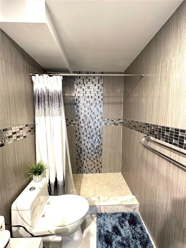 427 Golden Isles Dr Unit 5G, Hallandale Beach, FL 33009 - full bathroom with tile walls, a tile shower, and toilet