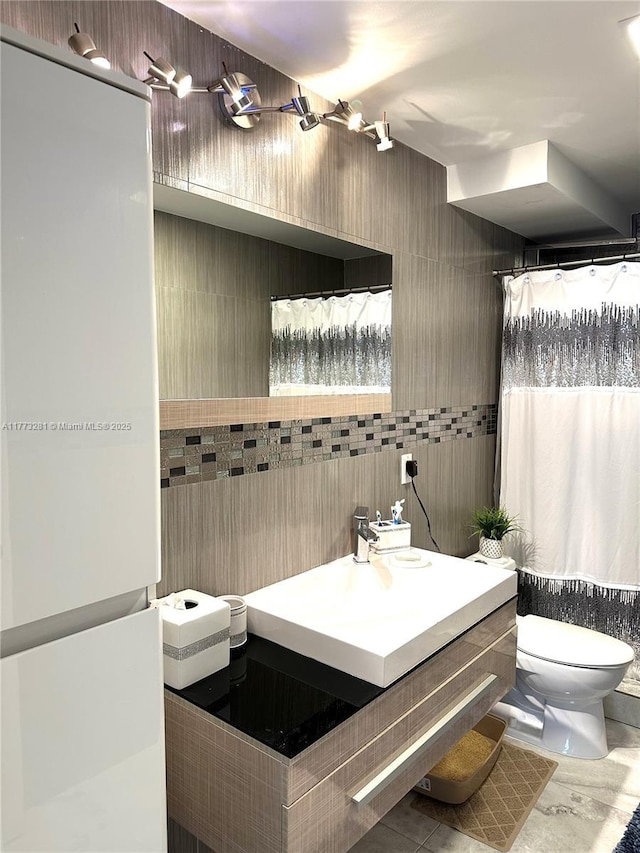 427 Golden Isles Dr Unit 5G, Hallandale Beach, FL 33009 - bathroom with vanity, tile walls, and toilet