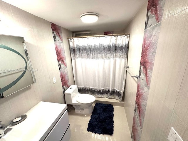 427 Golden Isles Dr Unit 5G, Hallandale Beach, FL 33009 - bathroom with toilet, vanity, and tile walls