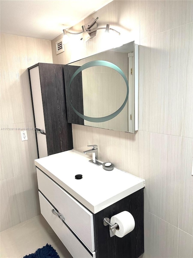 427 Golden Isles Dr Unit 5G, Hallandale Beach, FL 33009 - bathroom featuring vanity, visible vents, and tile walls