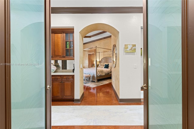 corridor featuring wood finished floors and arched walkways