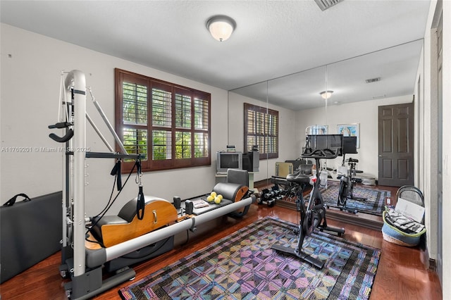 exercise area with visible vents and wood finished floors