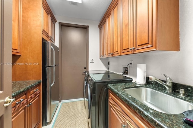 washroom featuring visible vents, washing machine and clothes dryer, and a sink