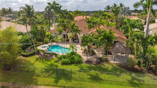 view of pool with a fenced backyard, a pool with connected hot tub, a lawn, and a patio