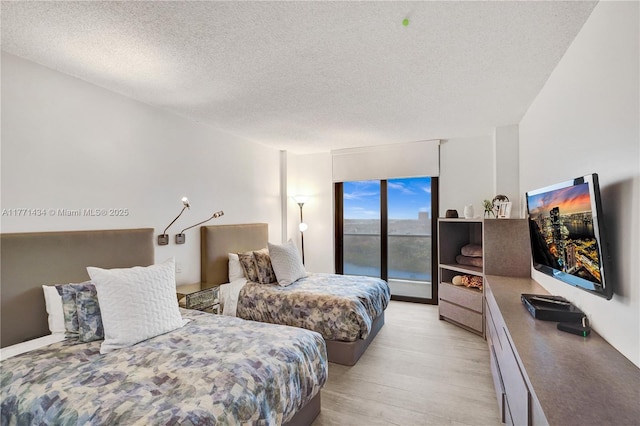 20281 E Country Club Dr Unit 1002, Aventura, FL 33180 - bedroom featuring light wood-style flooring and a textured ceiling