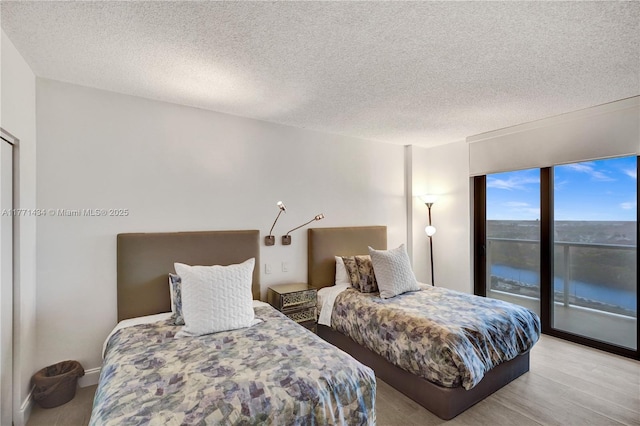 20281 E Country Club Dr Unit 1002, Aventura, FL 33180 - bedroom with access to outside, a textured ceiling, and wood finished floors