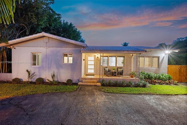 74 NE 103rd St, Miami Shores, FL 33138 - view of front of house featuring covered porch, a tile roof, and stucco siding